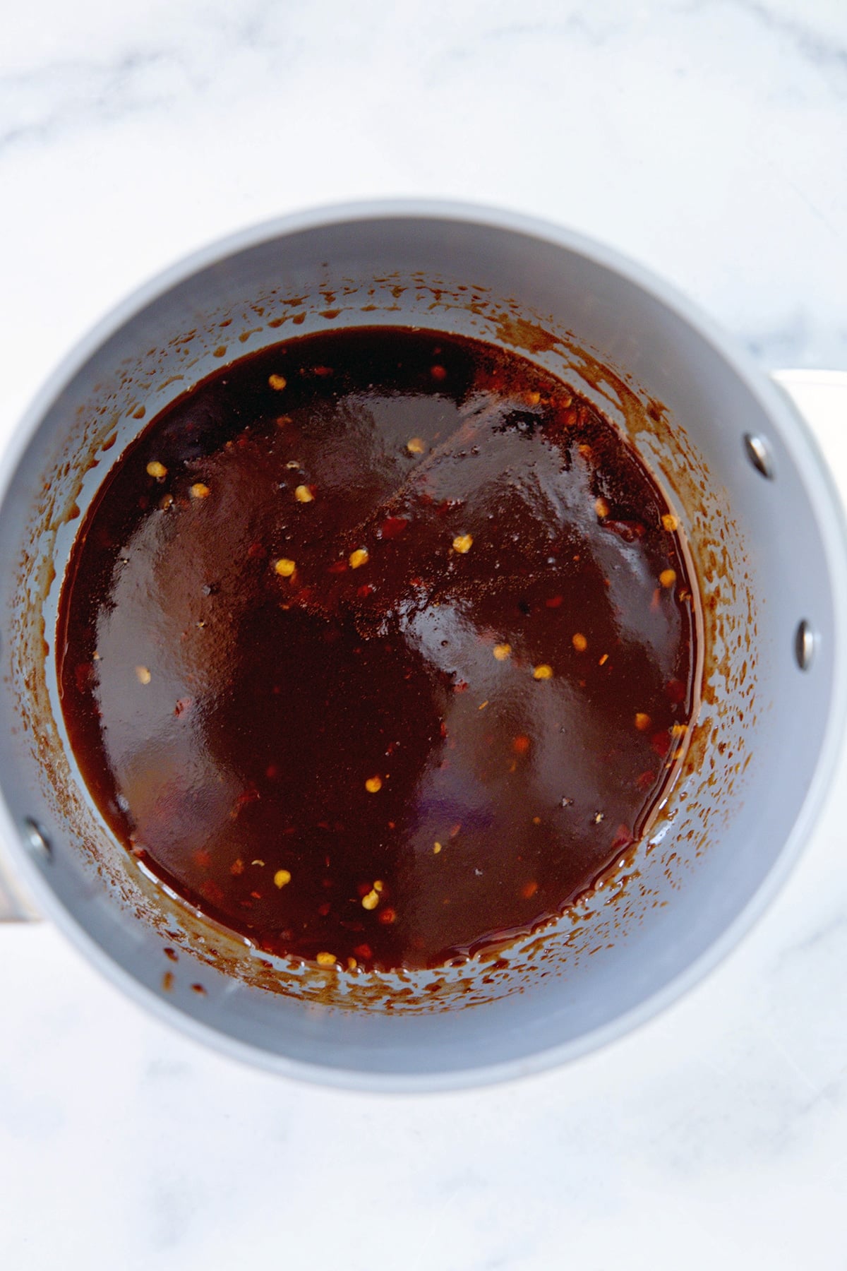 Sweet and spicy sauce simmering in saucepan.