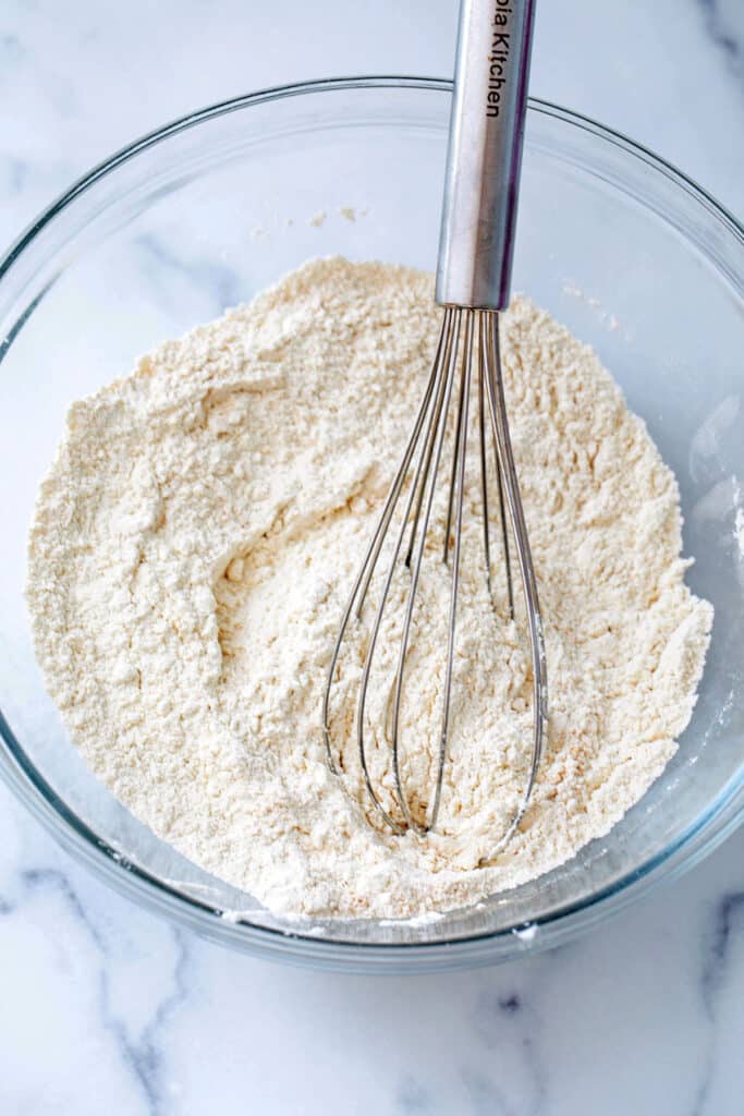 Flour and dry ingredients in mixing bowl with whisk.