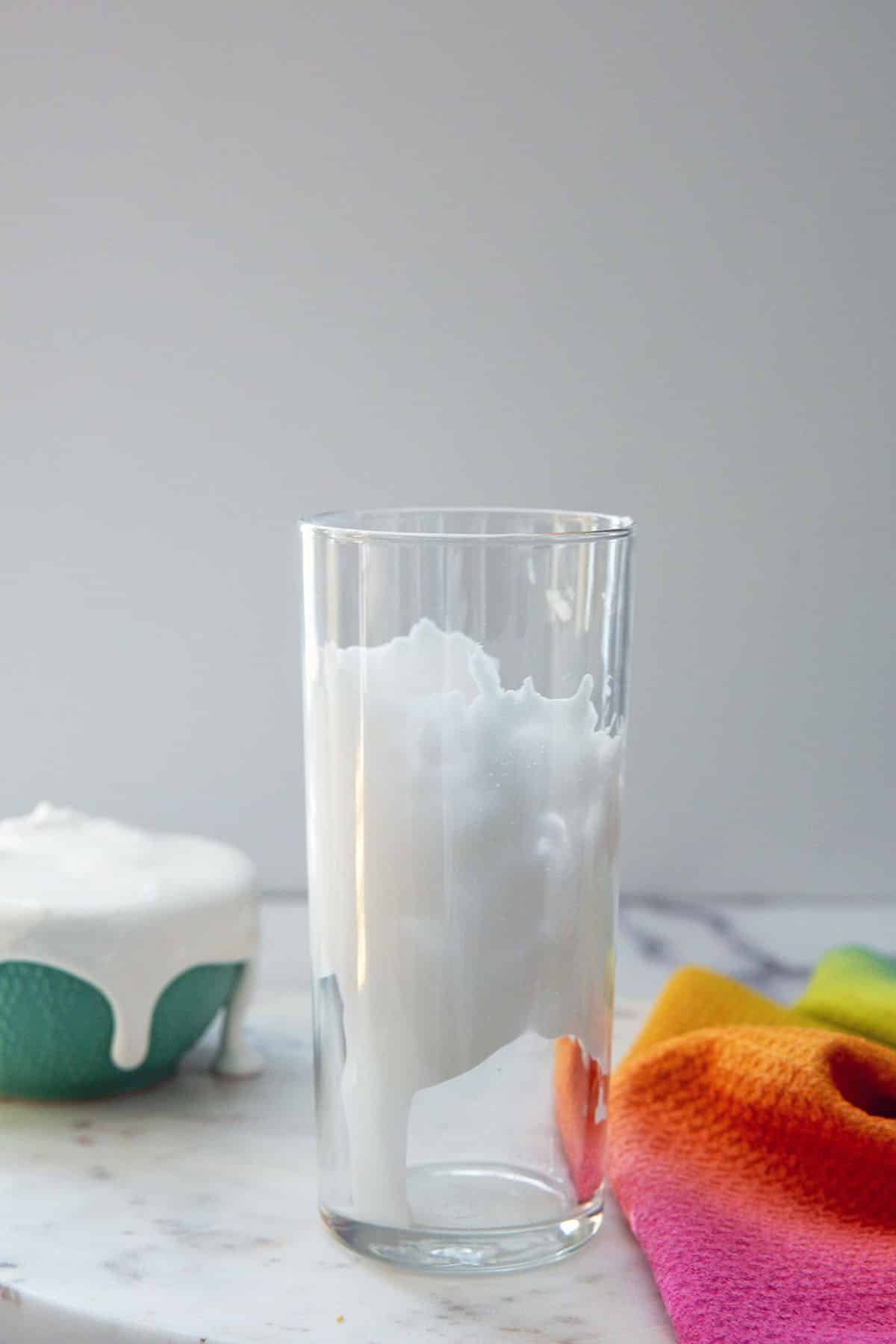 Fluff lined glass with bowl of fluff in background.