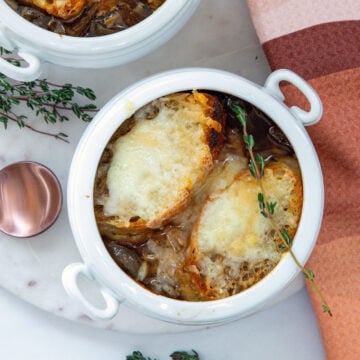Closeup overhead view of french onion chicken soup with croutons and melted cheese.