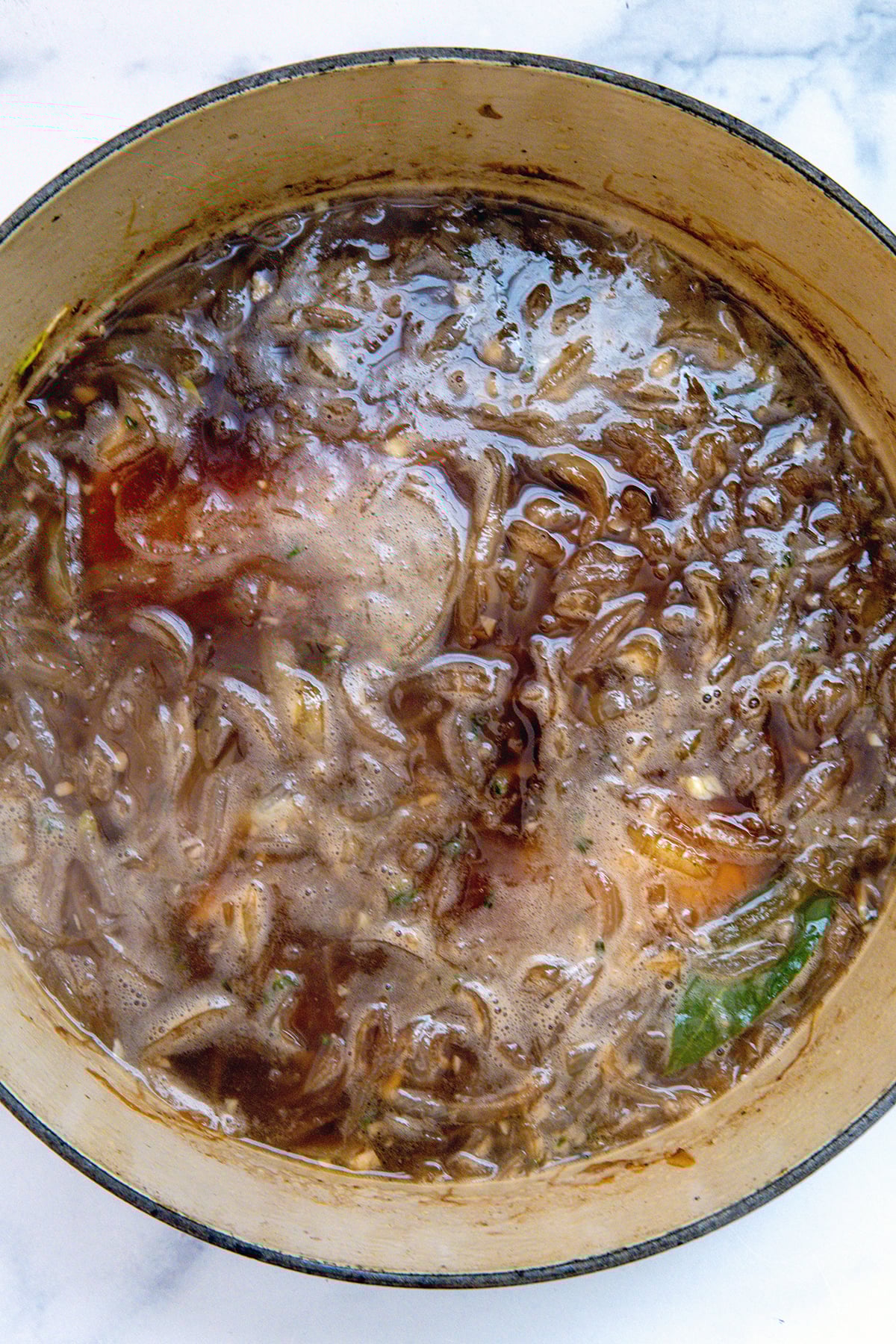 French onion soup simmering in saucepan.