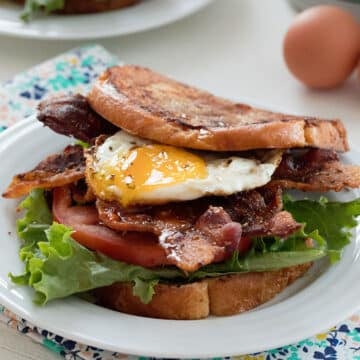 Closeup view of a French toast BLT sandwich with an egg.