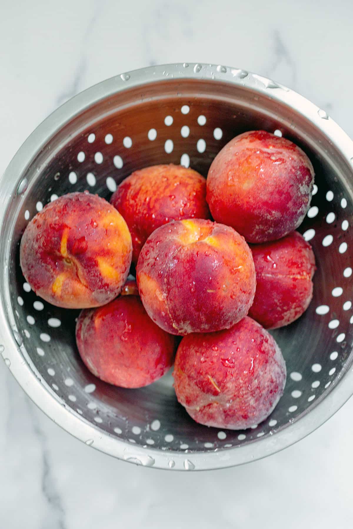 Fresh peaches in strainer.