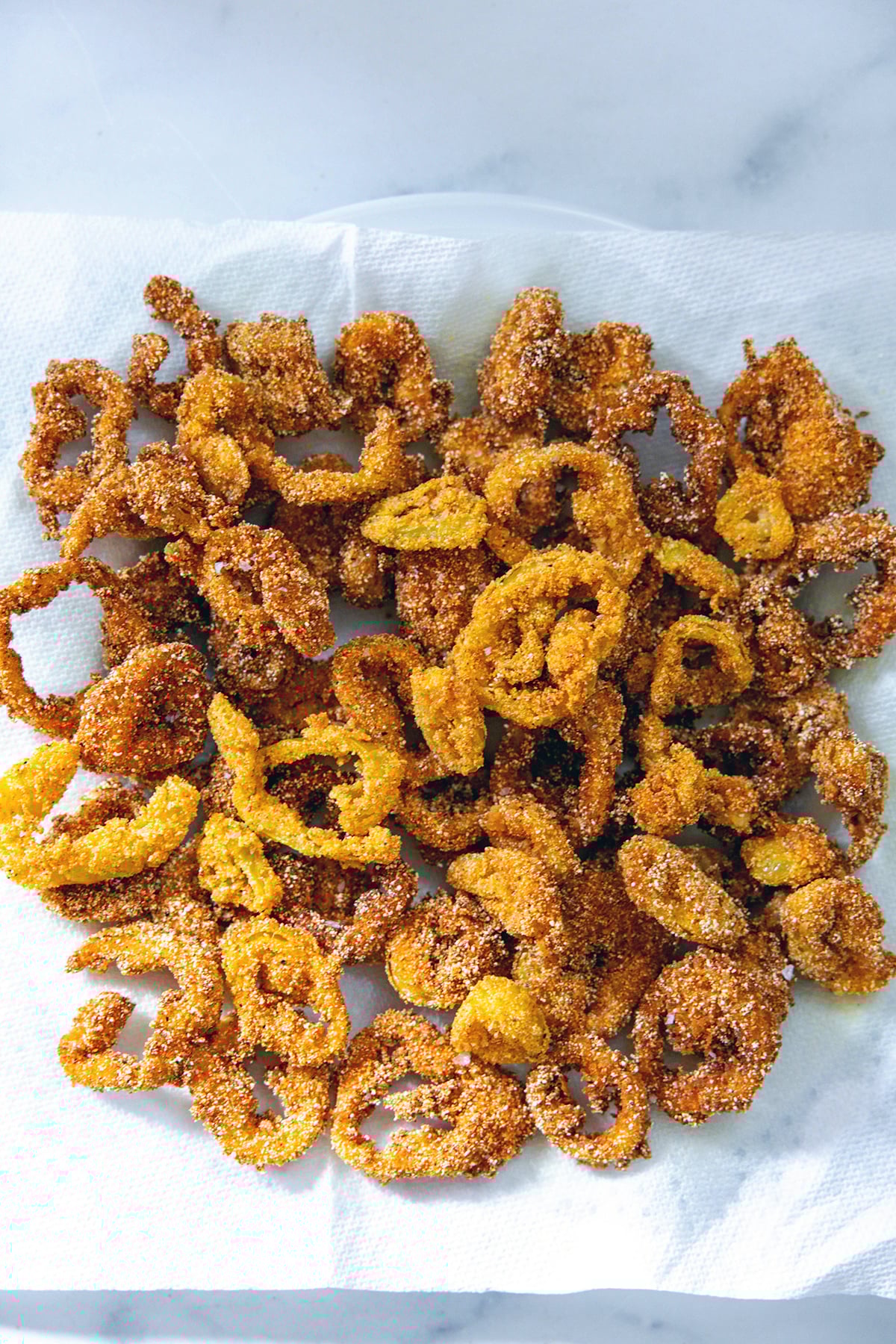 Crispy fried banana peppers on a paper towel.