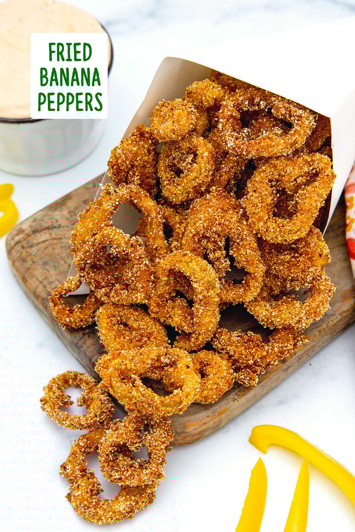 Fried banana pepper rings on a wooden board with recipe title at top.