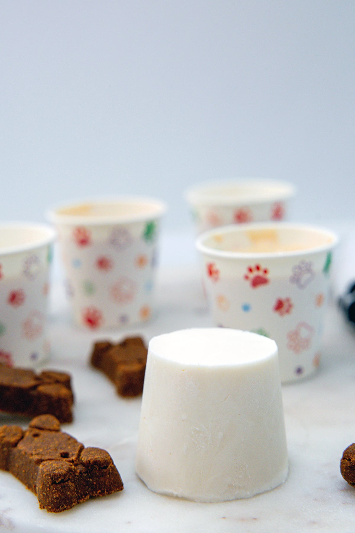 Head-on view of a homemade Frosty Paws ice cream with dog bones and more ice cream cups in background.