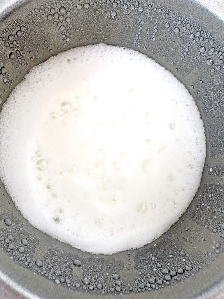 Frothed milk in an electric frother.