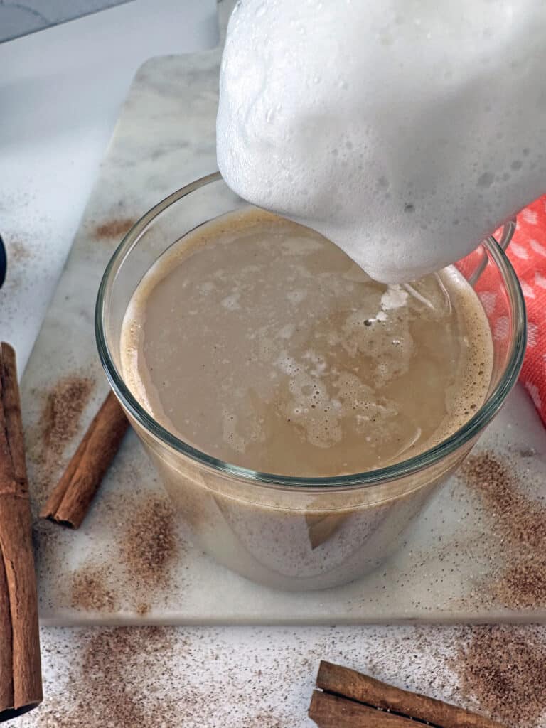 Frothed milk being added to cinnamon dolce latte.