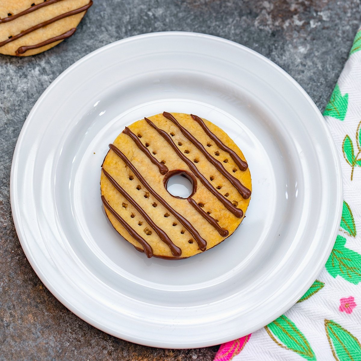 Closeup view of a fudge stripes cookie on a white plate.