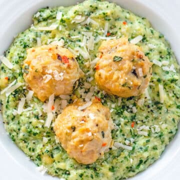 Closeup overhead view of chicken meatballs served over kale polenta.