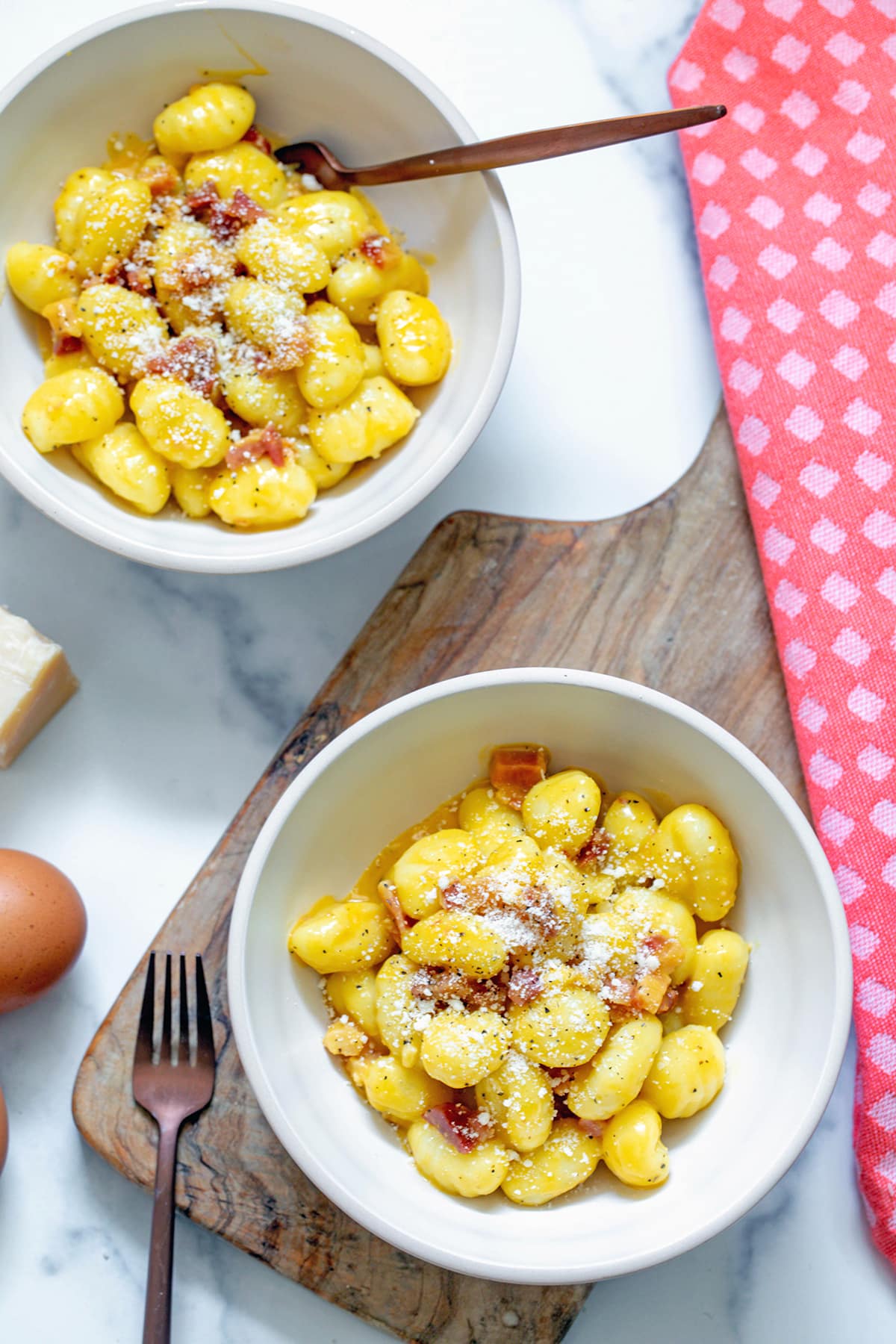 Overhead view of two bowls of gnocchi carbonara.