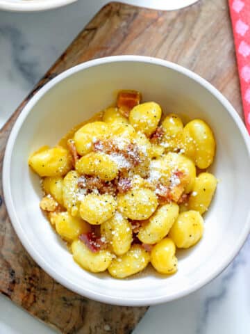 Overhead close-up view of a bowl of gnocchi carbonara.