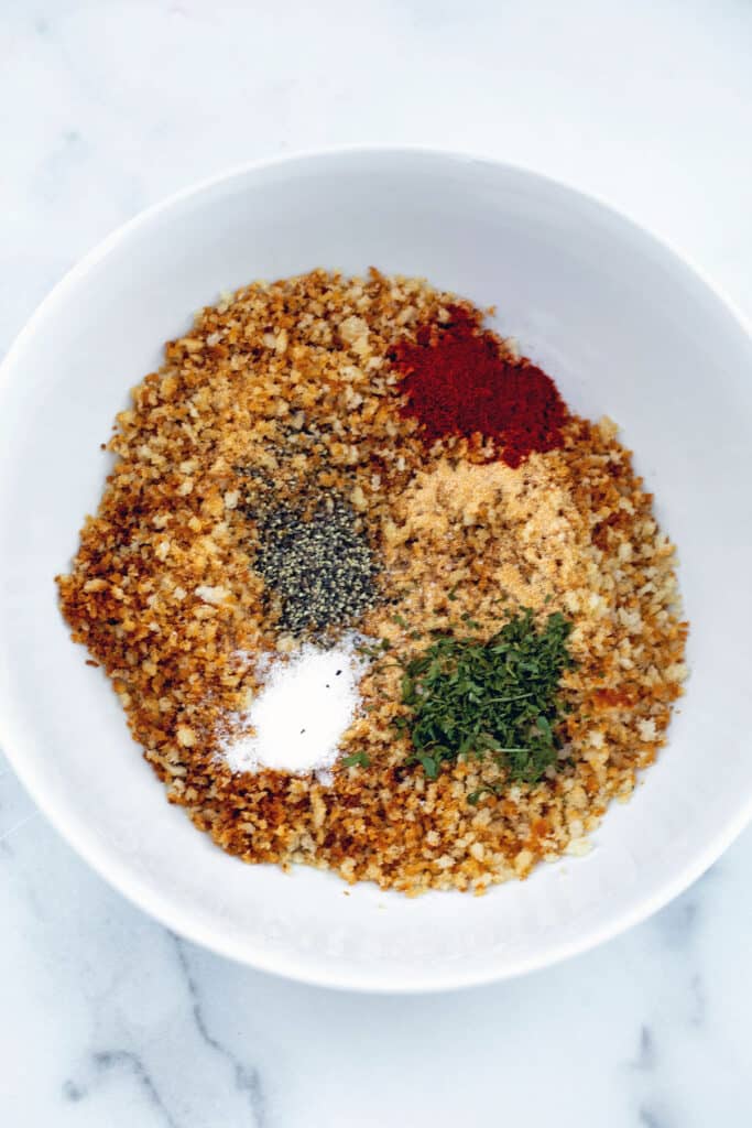 Golden panko with salt, pepper, garlic powder, paprika, and dried parsley in bowl.