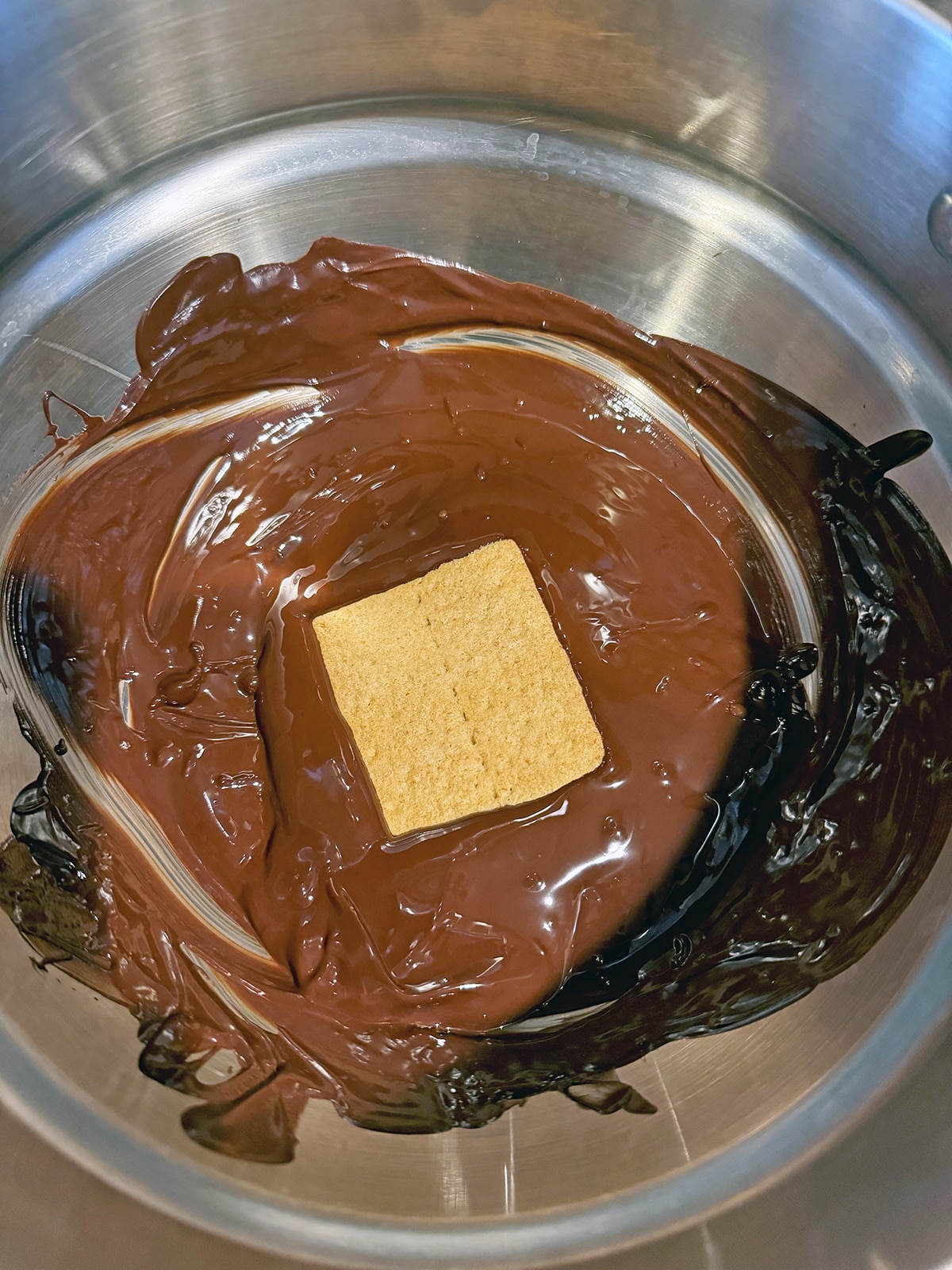 Graham cracker in melted chocolate in double boiler.