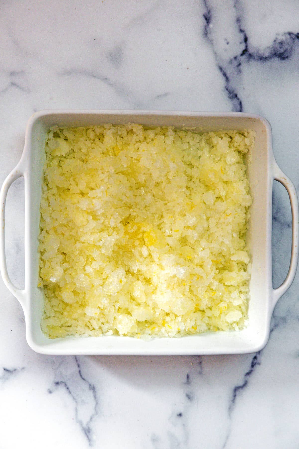 Frozen lemonade granita in baking dish.