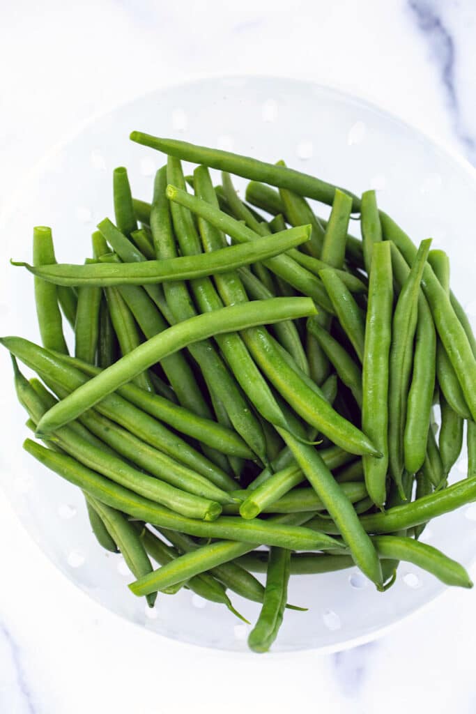 Fresh green beans in a strainer.