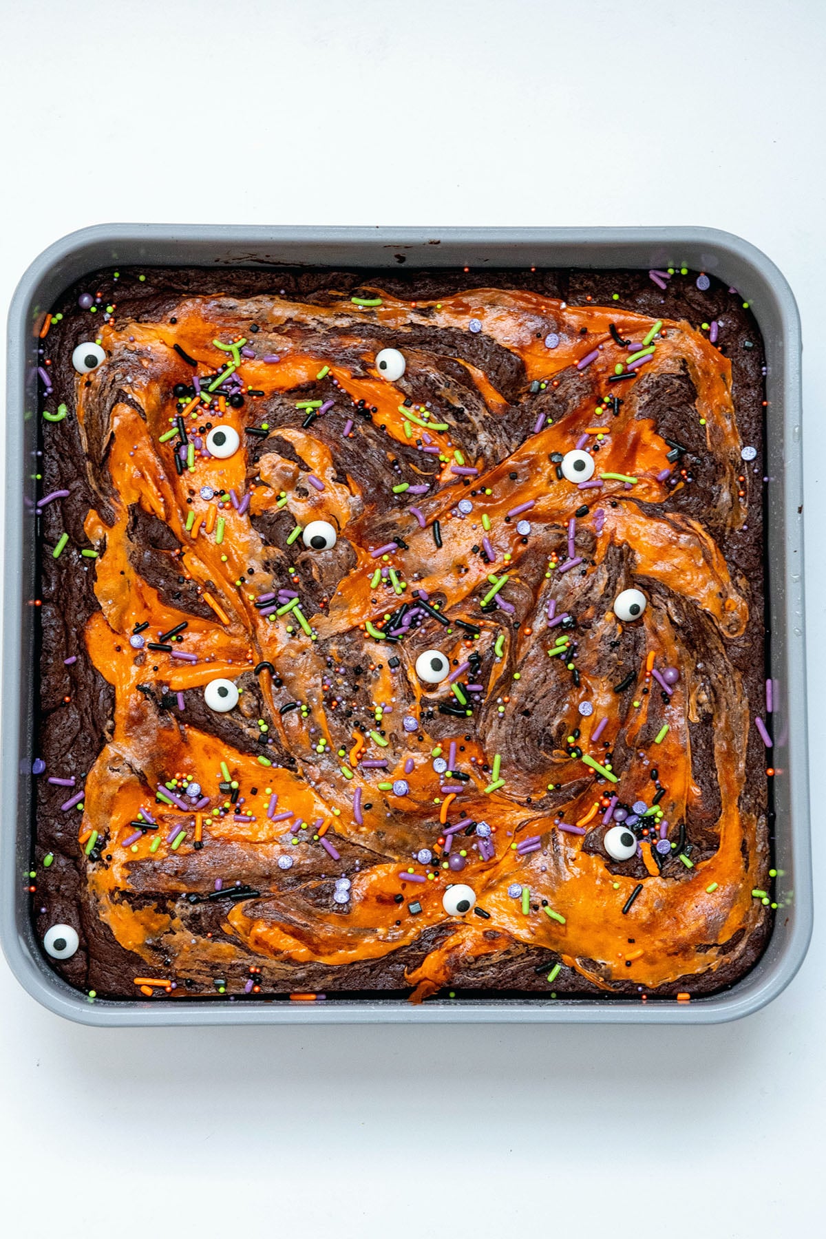 Orange cream cheese swirled Halloween brownies with sprinkles and candy eyes.