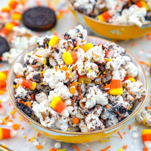 Closeup view of Halloween popcorn in a bowl with candy corn, chocolate, and sprinkles.