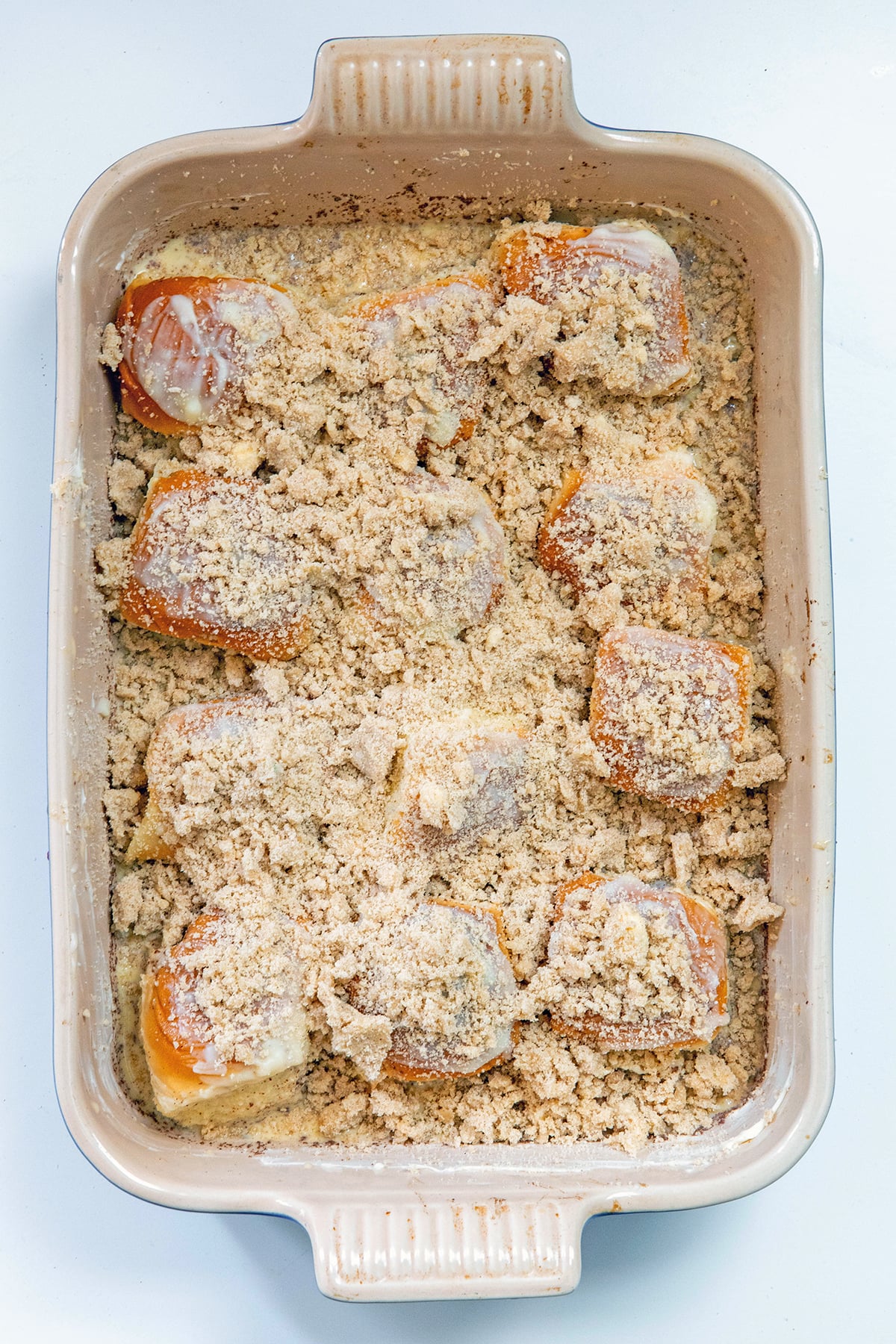Overhead view of casserole dish with Hawaiian roll french toast casserole assembled and topped with streusel.