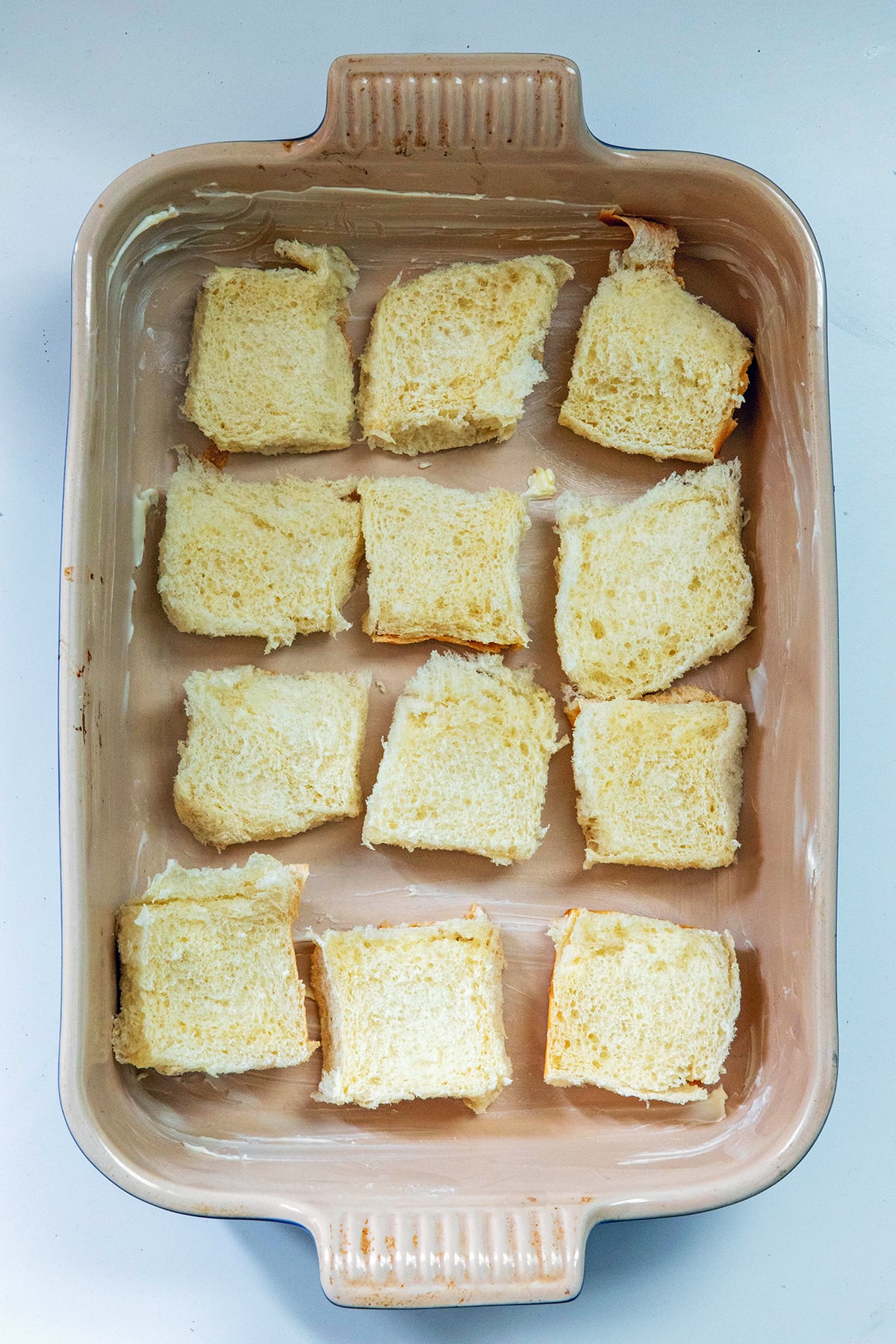 Overhead view of sliced Hawaiian rolls in a casserole dish.