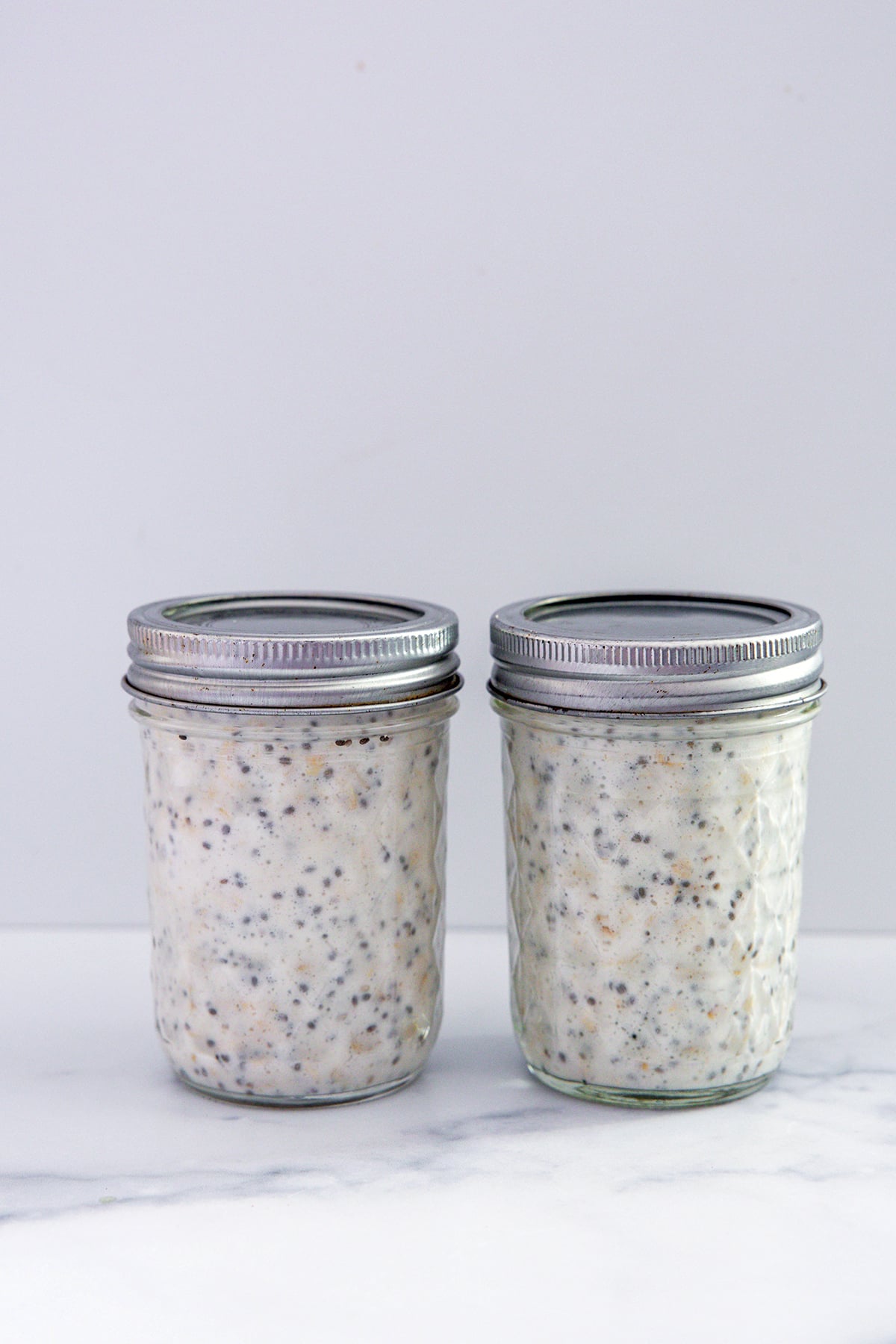 Two jars of protein overnight oats ready to go into fridge.