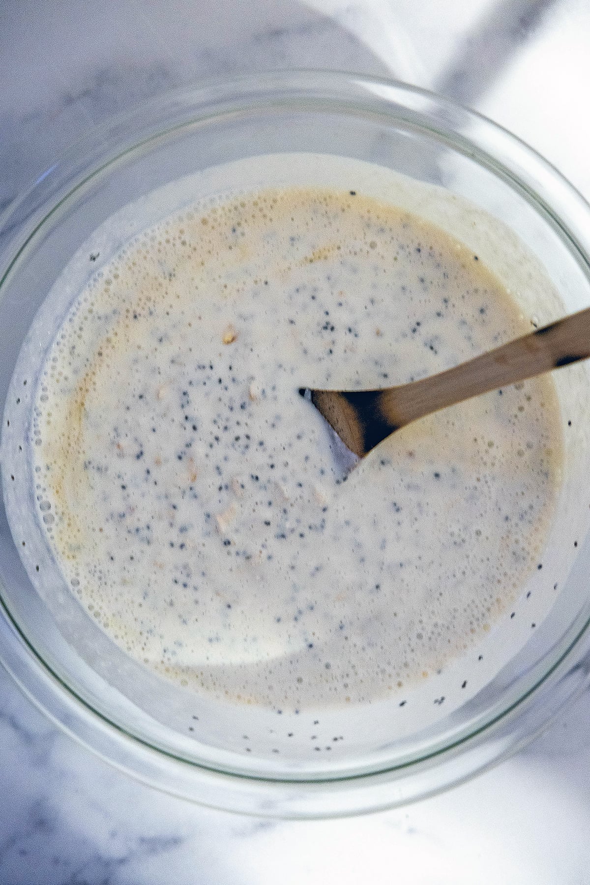 Overhead view of high-protein overnight oats mixed together in bowl with spoon.