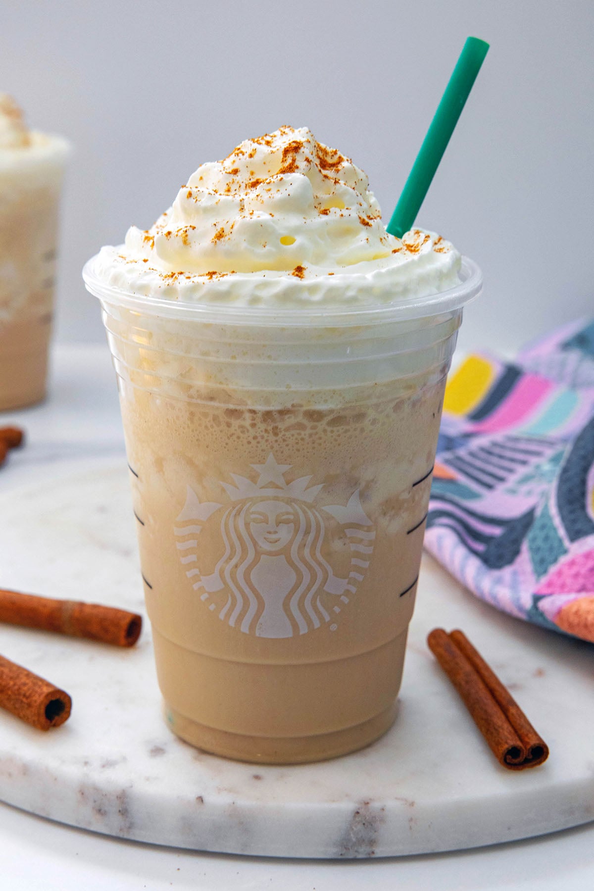 Closeup overhead view of Horchata Frappuccino in Starbucks cup with whipped cream and green straw.