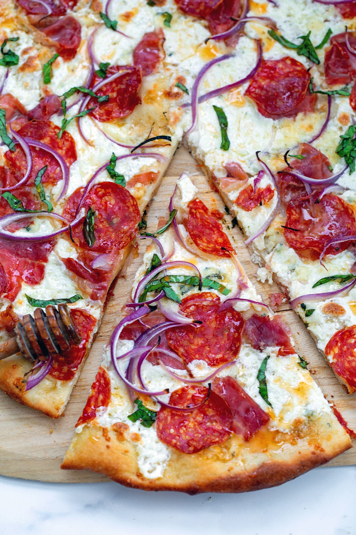 Overhead view of a hot honey pizza with a sliced pulled out.