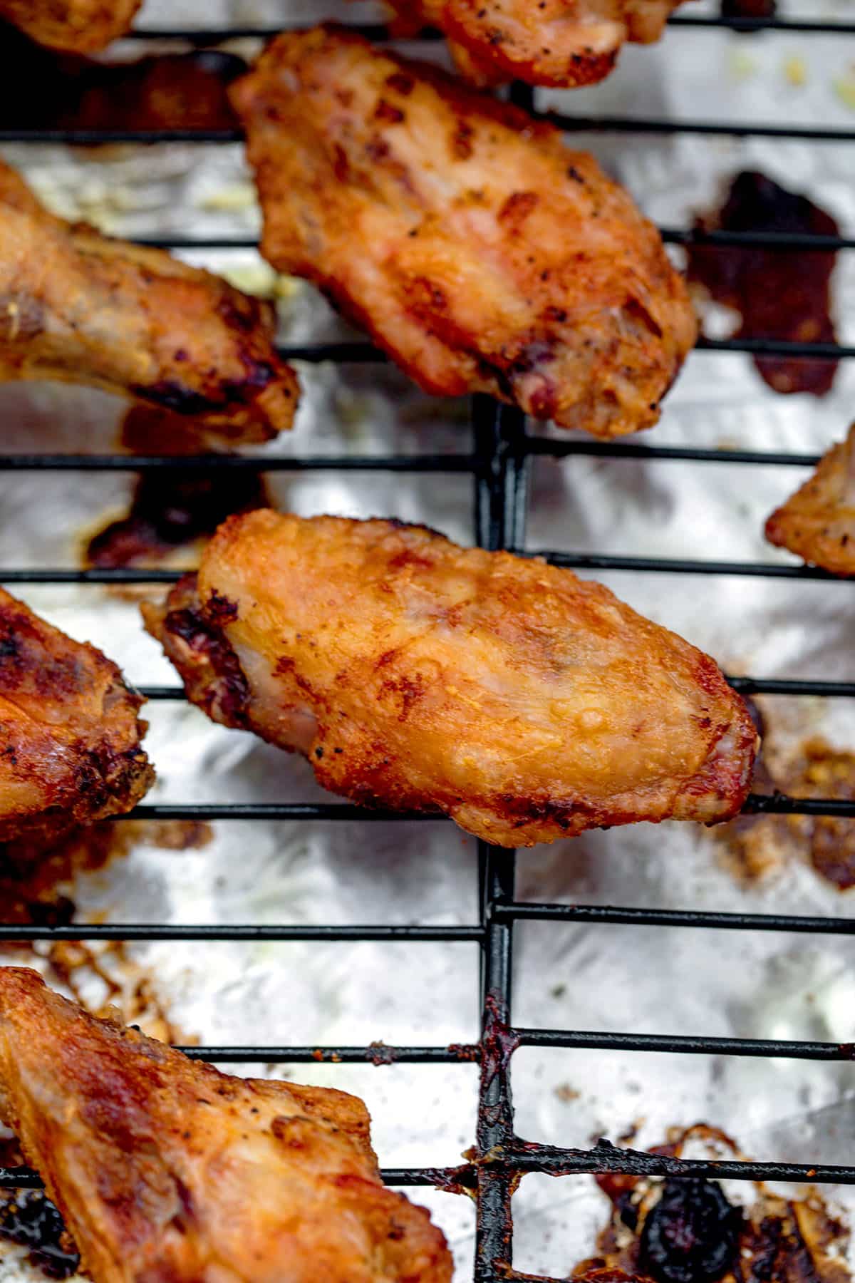 Baked chicken wings on a metal rack just out of the oven.