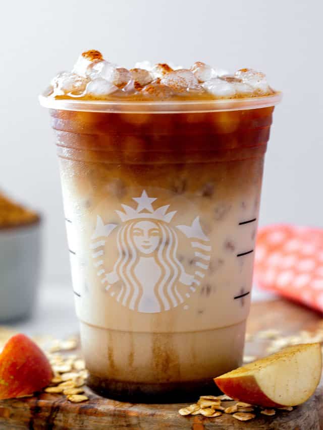 Head-on view of an iced apple crisp oatmilk macchiato in a Starbucks cup.