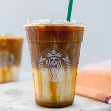 Head-on closeup view of an Iced Caramel Macchiato in a Starbucks cup.