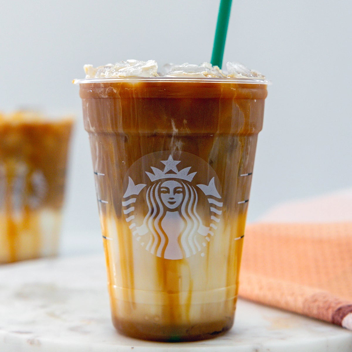 Head-on closeup view of an Iced Caramel Macchiato in a Starbucks cup.