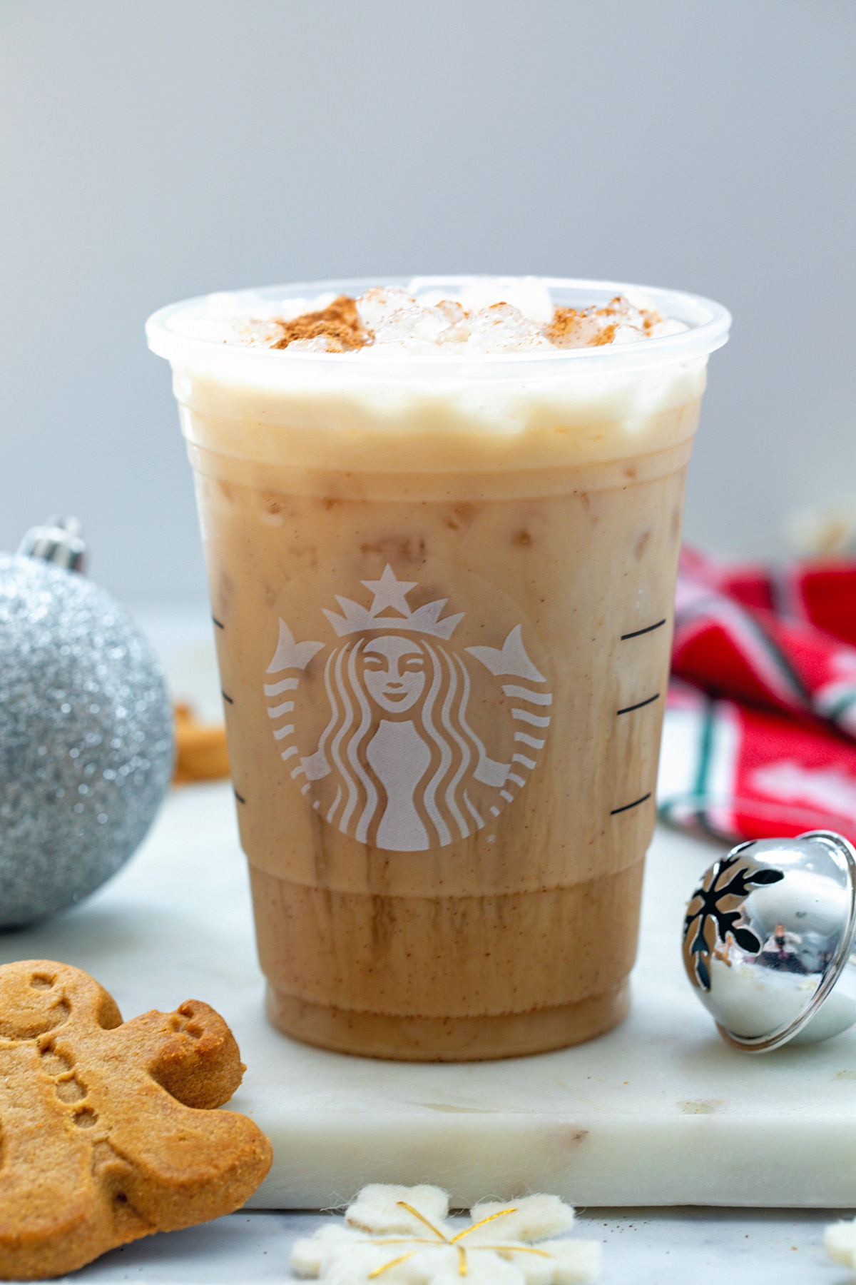 Iced Gingerbread Oatmilk Chai Latte with gingerbread man.