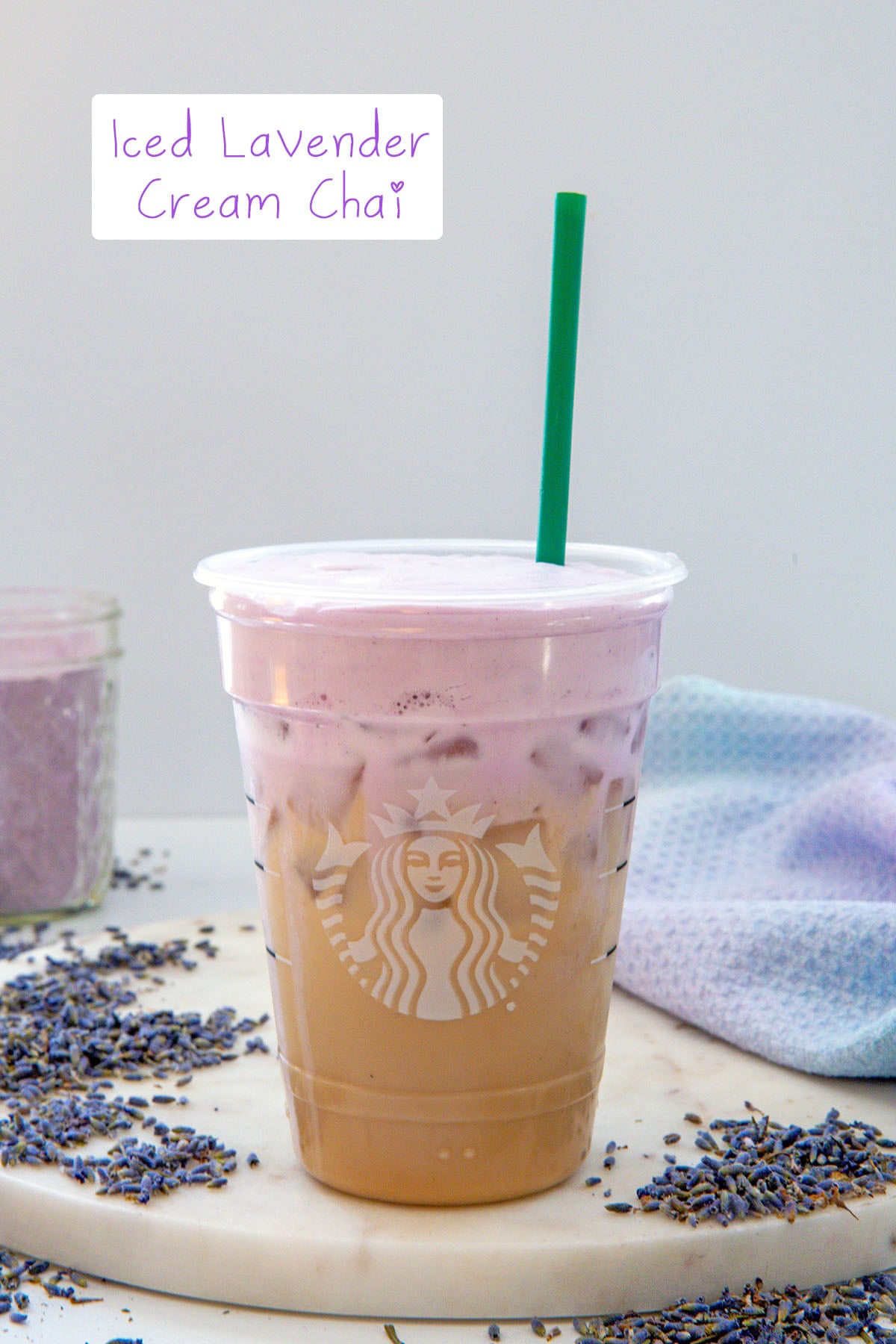 Head-on view of an iced chai with lavender cold foam with green straw and recipe title at top.