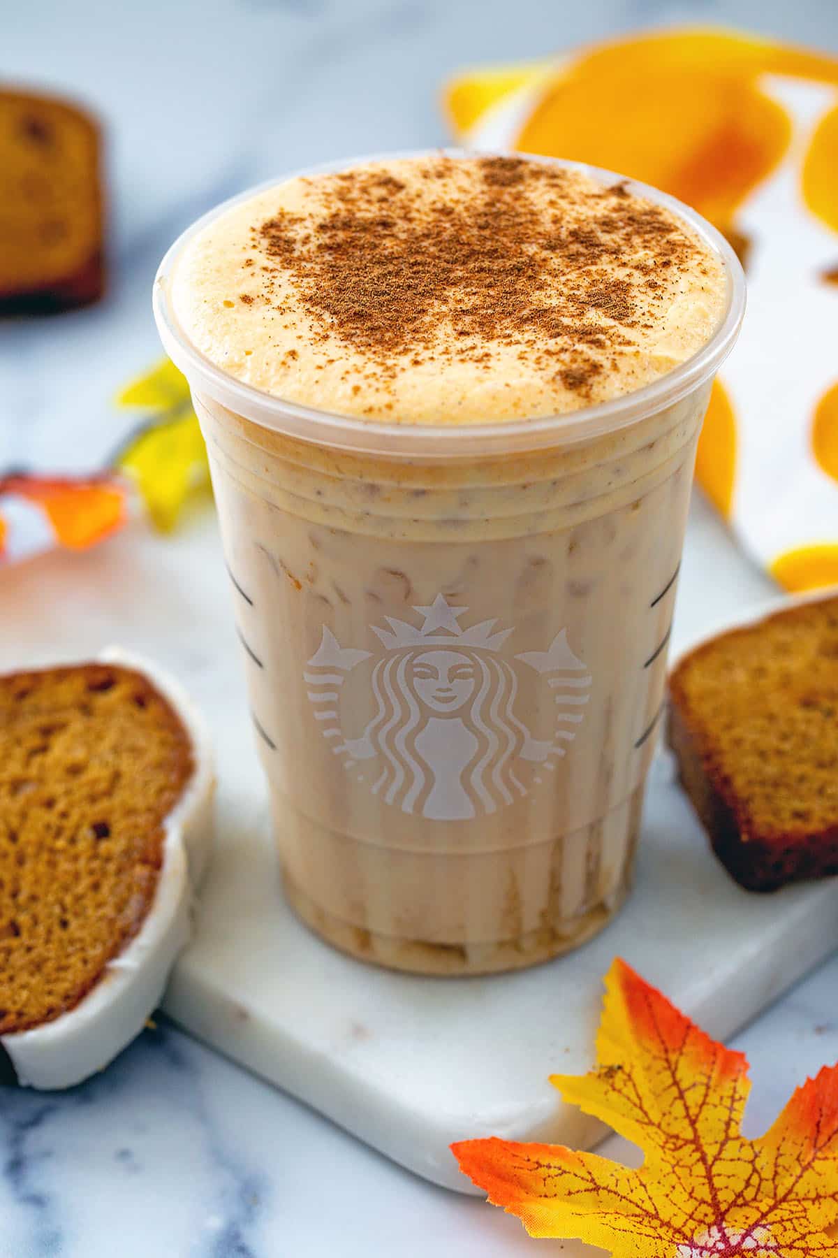 Overhead view of an iced pumpkin cream chai tea latte with cinnamon sprinkled on top.