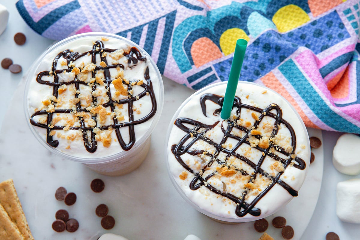 Landscape overhead view of two Iced S'mores Chais showing chocolate drizzle and graham cracker crumbs on top.