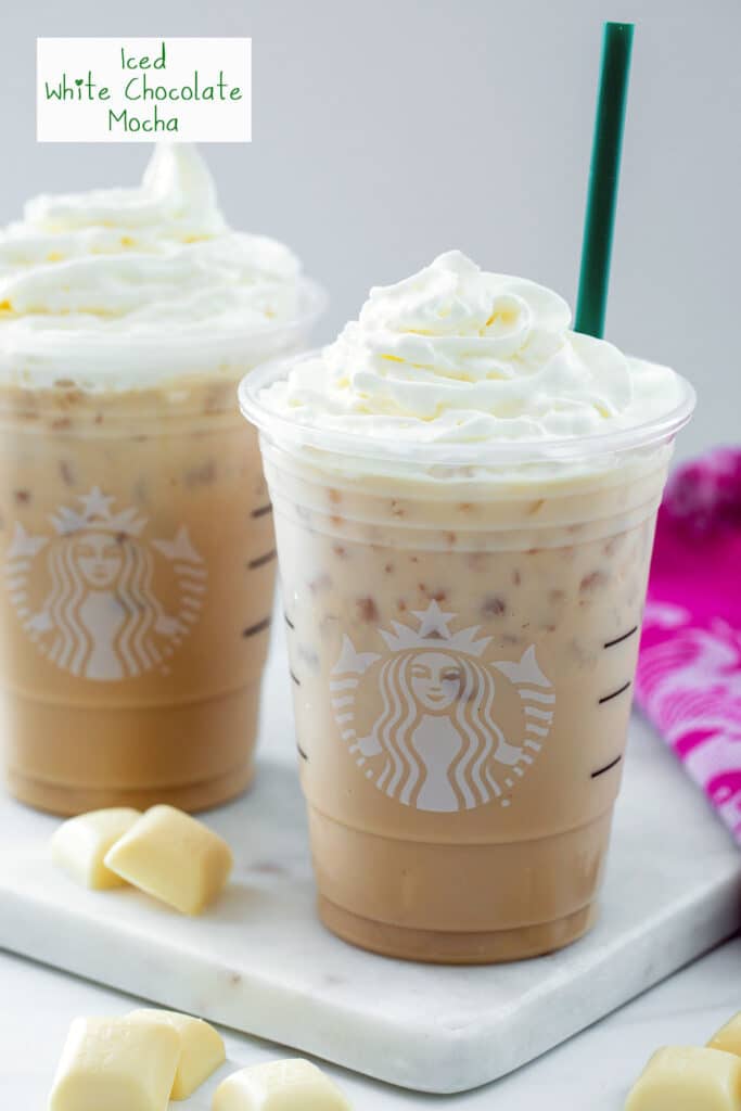Head-on view of an iced white chocolate mocha with whipped cream with second drink in background, blocks of white chocolate, and recipe title at top.