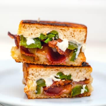 Closeup view of two halves of a jalapeño popper grilled cheese stacked on one another.