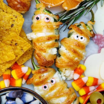 Closeup view of jalapeño popper mummies surrounded by candy corn.