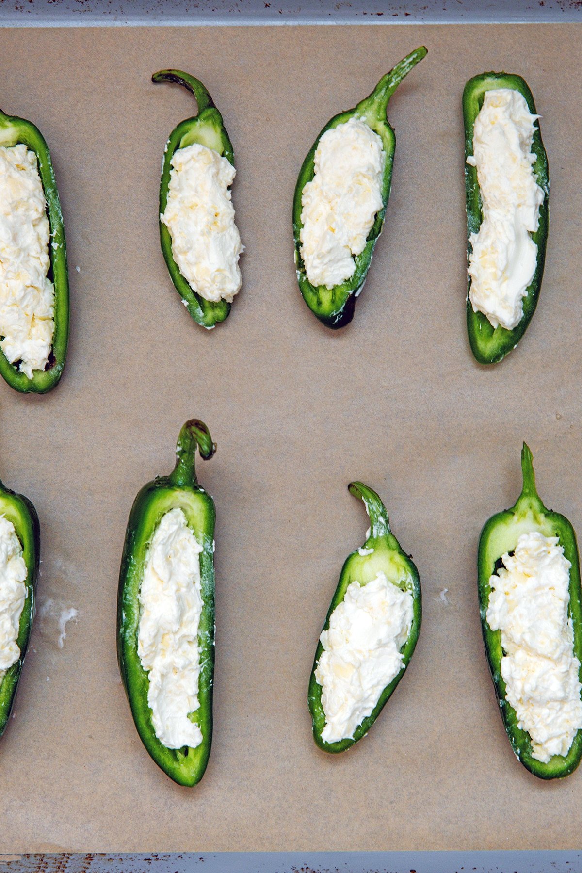 Halved jalapeño peppers filled with cream cheese and shredded cheese mixture.