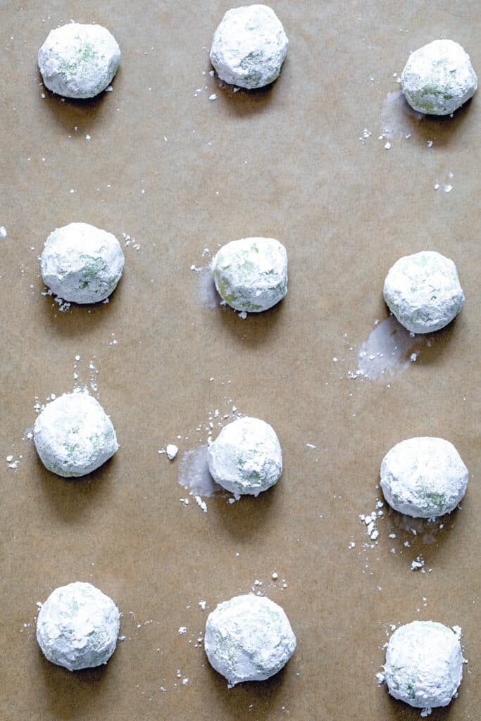 Cookie dough balls rolled in confectioners' sugar and placed on baking sheet. 
