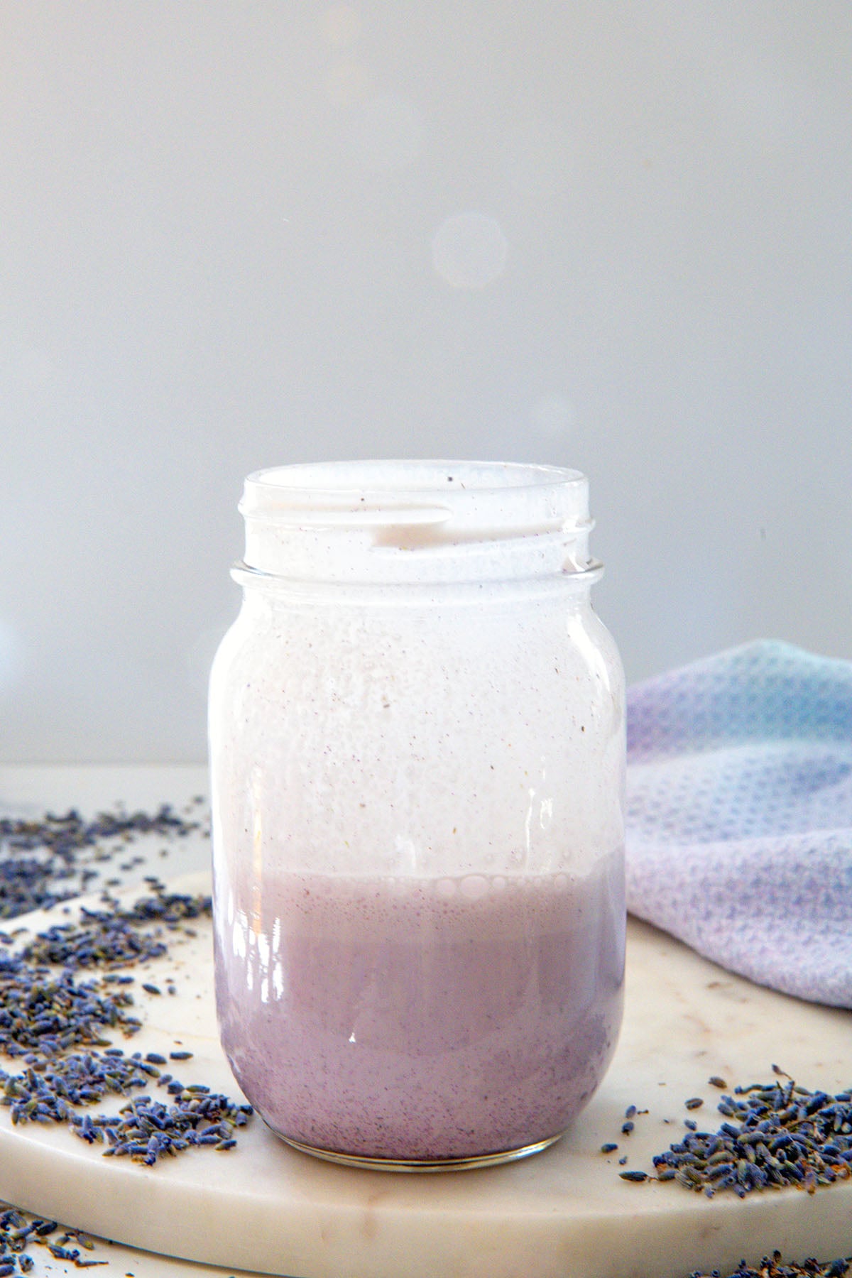 Lavender sweet cream in mason jar with lavender flowers all around.
