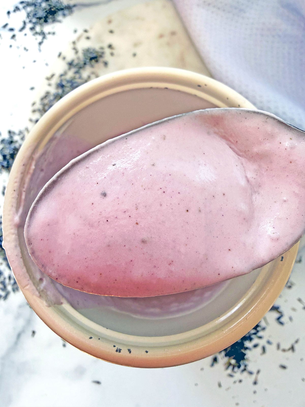 Lavender cream cold foam on a spoon.