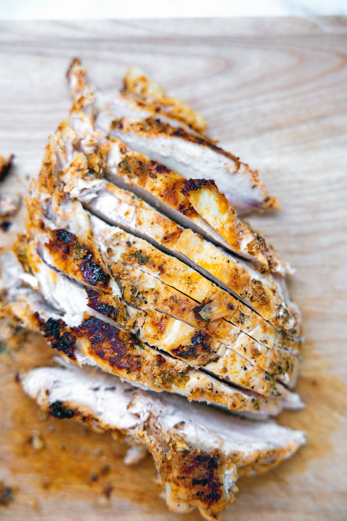 Sliced chicken breast on cutting board.