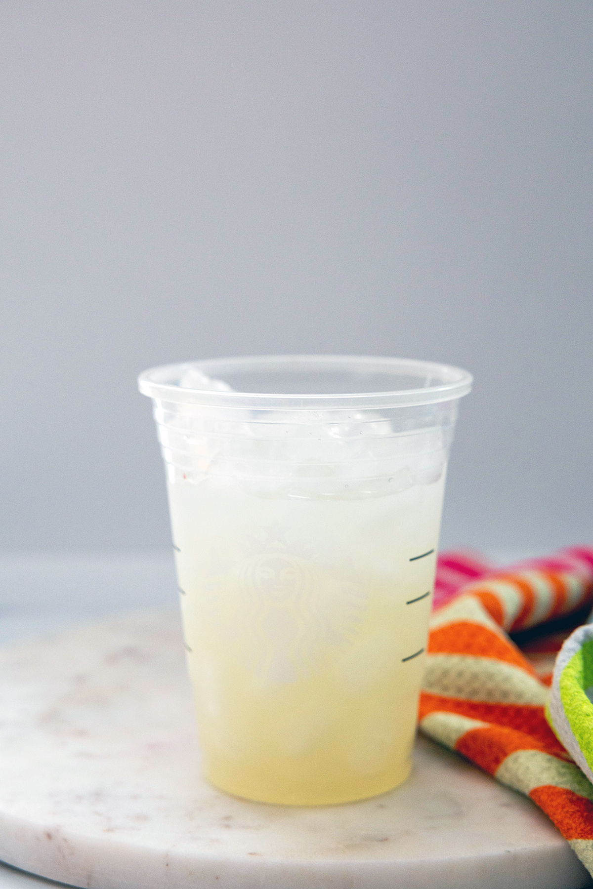 Head-on view of lemonade topped with ice in a Starbucks cup.