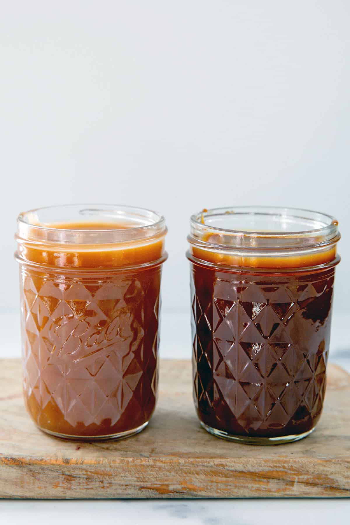 Jar of regular caramel sauce next to a jar of dark caramel sauce.