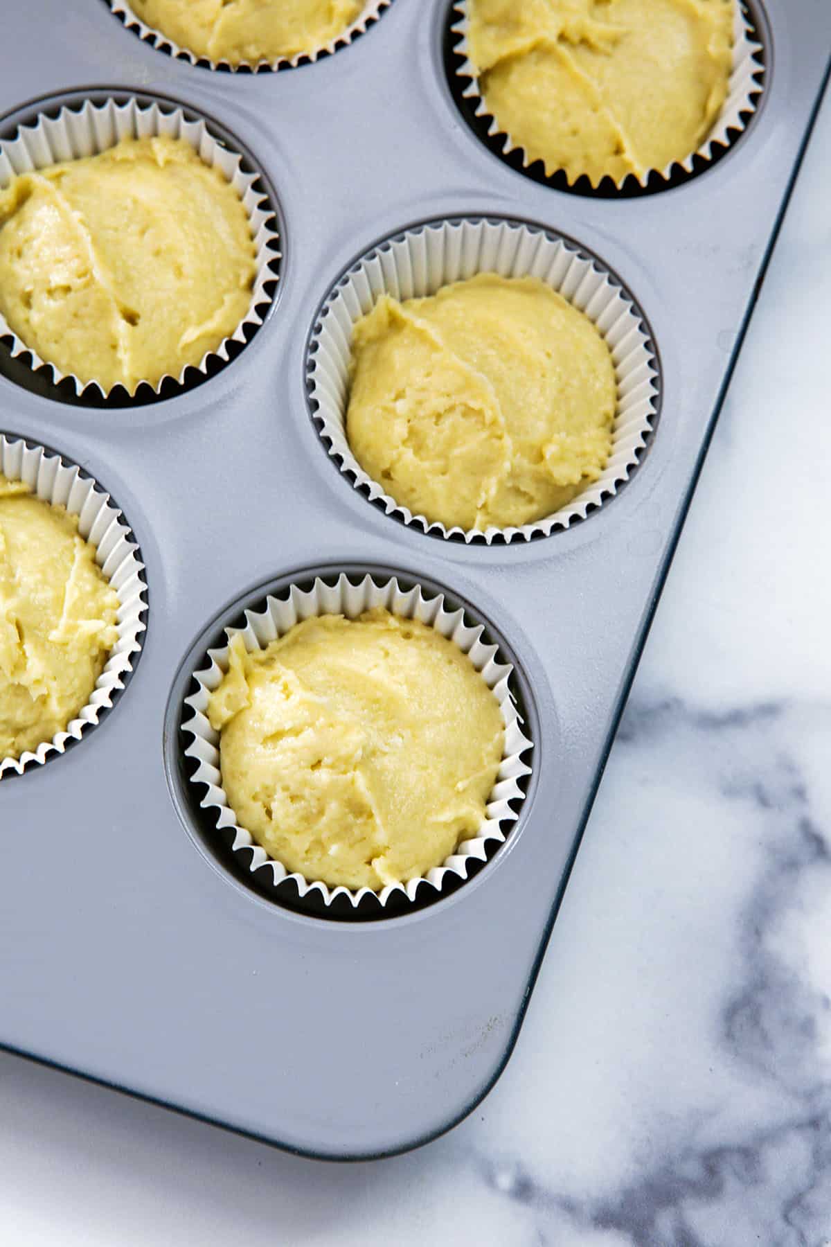 Cupcake batter in papers in tin.