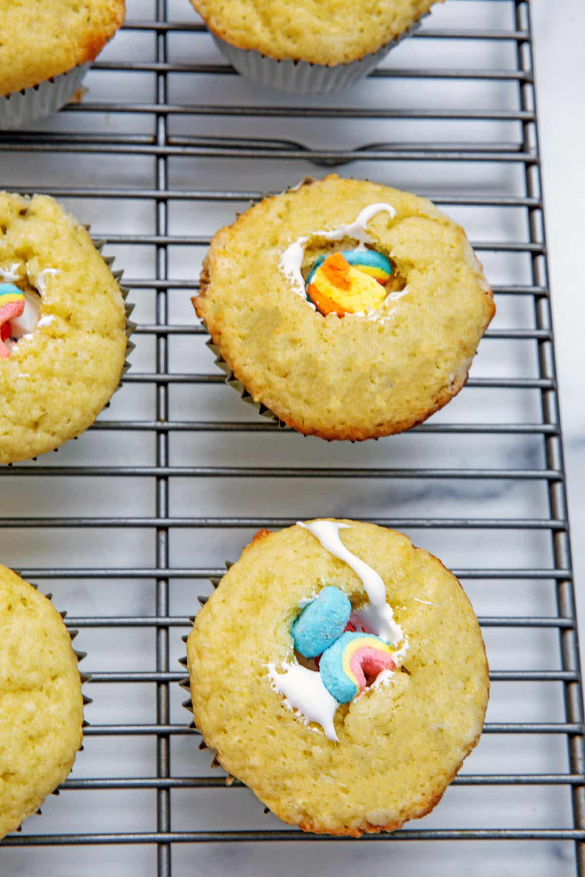 Cupcakes with core cut out and filled with marshmallow fluff and Lucky Charms marshmallows.
