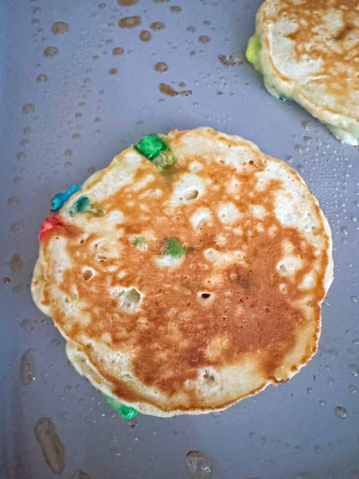 Lucky Charms pancakes cooked on griddle.