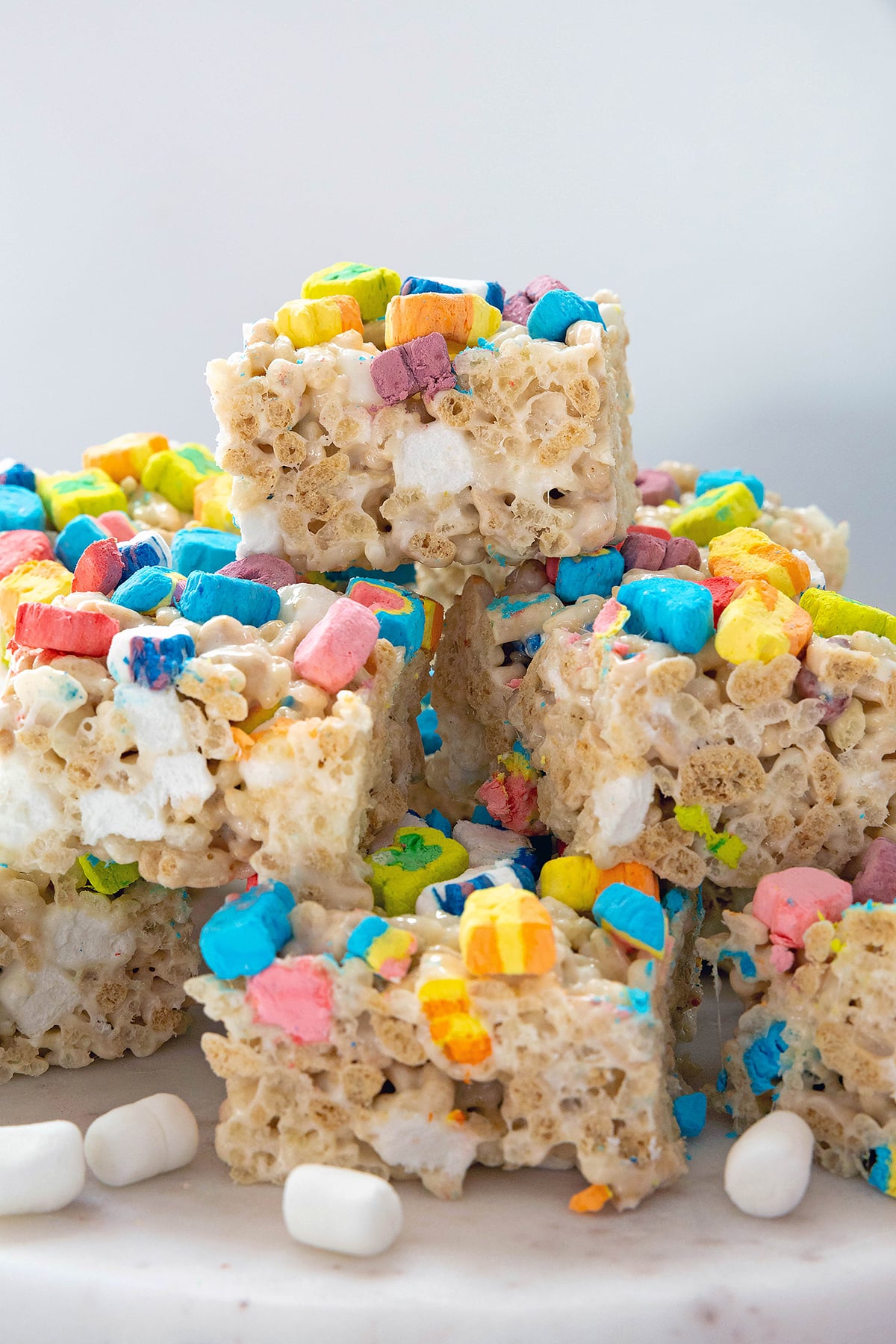 Head-on view of a stack of Lucky Charms Rice Krispies treats on a marble platter.
